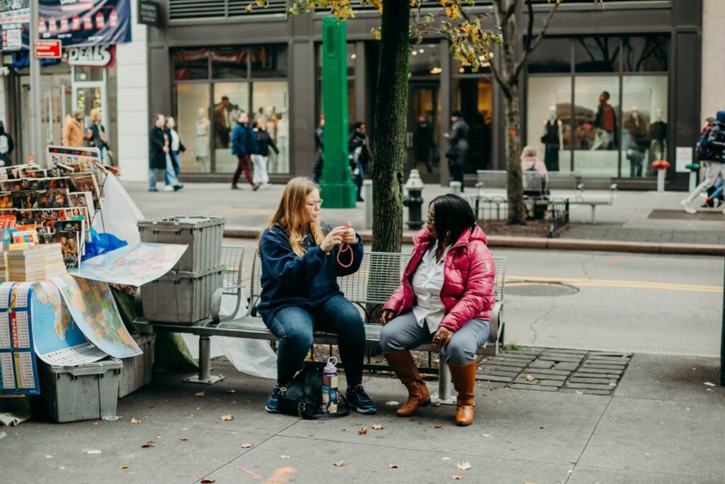 Two people talking on a city bench